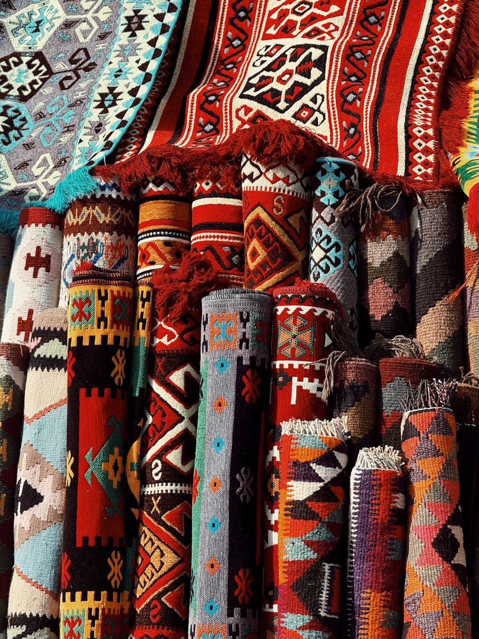 Vibrant display of handmade carpets with geometric patterns at an Iraqi bazaar.